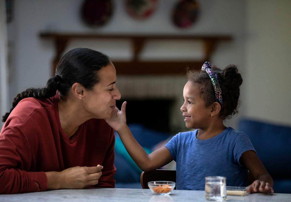 Mavis Daye, 5, right, and her mother, Kat Tedford, share a snack after school on Monday, May 9, 2022, at their home in Durham, N.C.