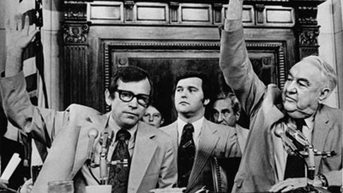 Sens. Howard Baker and Sam Ervin raise their hands to vote during a Senate Watergate Committee meeting. Rufus Edmisten, then the committee’s deputy chief counsel, is at center.
