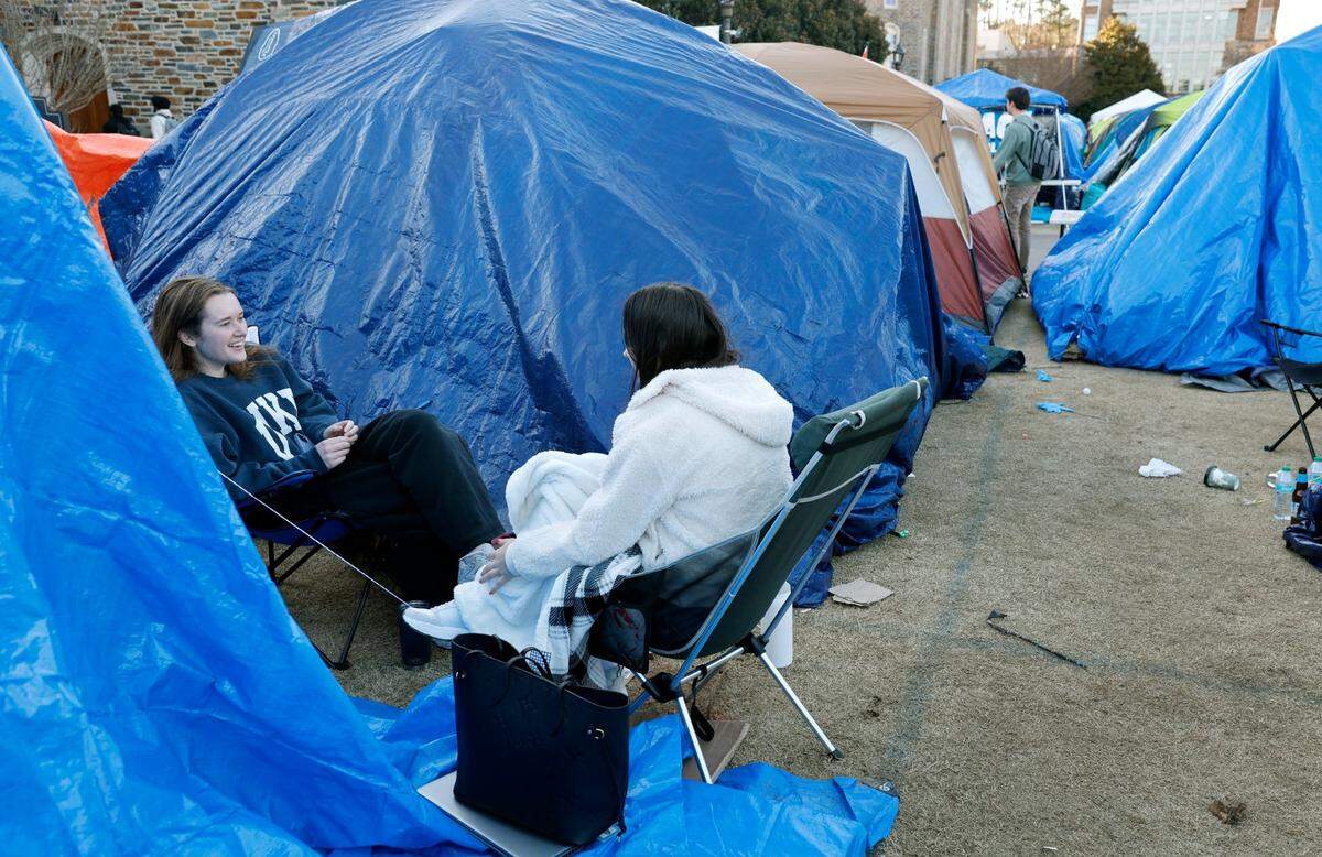 Duke seniors Julia Kubec, left, and Maddy Miller hang out in Krzyzewskiville at Duke University in Durham, N.C., Tuesday, Jan. 28, 2025. The is the 39th year of tenting for students who want to attend the game against UNC. One hundred thirty tents were set up on Jan. 12, with 12 students per tent. It is the only way undergraduates can go to the game.