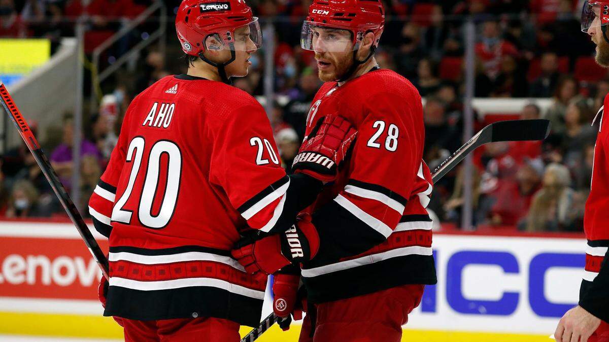 Carolina Hurricanes’ Sebastian Aho (20) talks with teammate Ian Cole (28) prior to a face-off against the Ottawa Senators during the third period of an NHL hockey game in Raleigh, N.C., Thursday, Dec. 2, 2021. (AP Photo/Karl B DeBlaker)