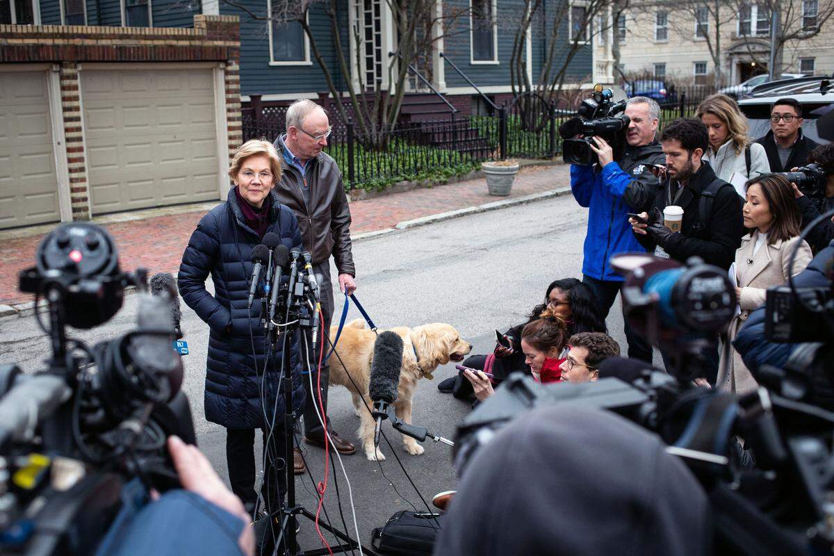 Sen. Elizabeth Warren (D-Mass.) is joined by her husband, Bruce Mann, and their dog, Bailey, as she speaks to reporters outside her home in Cambridge, Mass., on Monday, Dec. 31, 2018. Warren, a sharp critic of big banks and unregulated capitalism, entered the 2020 race for president on Monday, becoming the first major candidate in what is likely to be a long and crowded primary marked by ideological and generational divisions in a Democratic Party desperate to beat President Donald Trump. (Elizabeth Frantz/The New York Times)