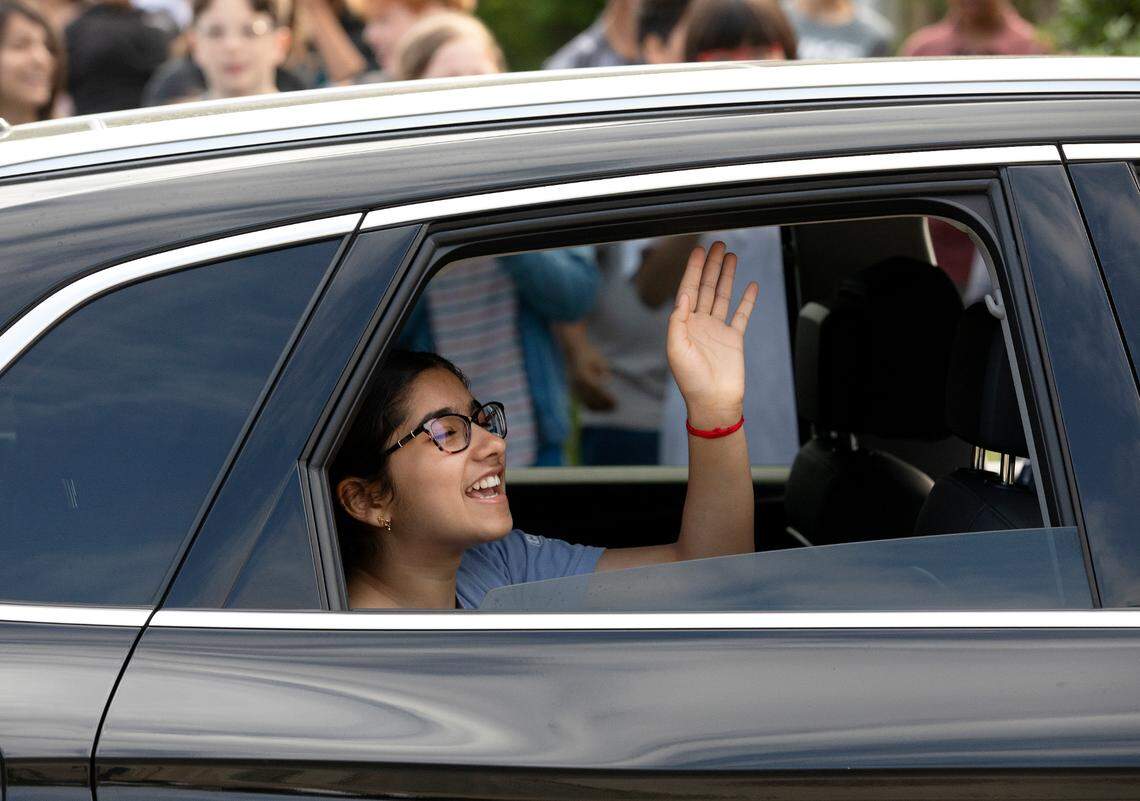 Davis Drive Middle School seventh-grader Ananya Rao Prassanna reacts while riding past hundreds of her classmates gathered in celebration on Monday, June 3, 2024, in Cary, N.C. to honor Prassanna’s third-place finish in the Scripps National Spelling Bee.