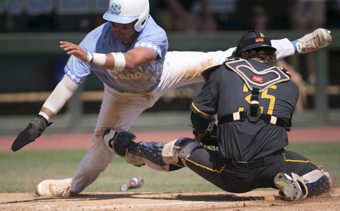 North Carolina’s Zack Gahagan (10) dives over North Carolina A&T catcher Ryne Stanley (35) to score on a sacrifice fly by teammate Ike Freeman in the sixth inning during the NCAA Regional on Friday, June 1, 2018, at Boshamer Stadium in Chapel Hill, N.C.