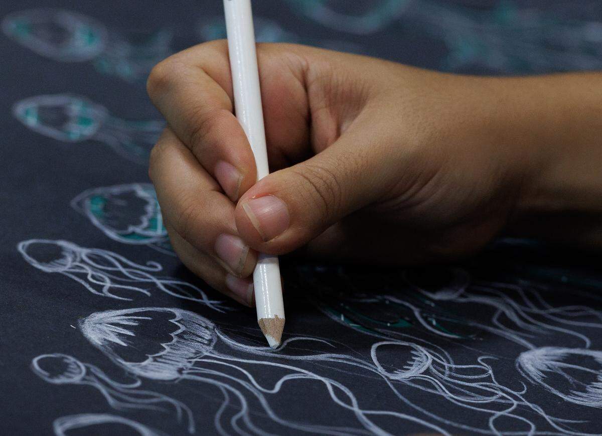 Hannah Rodriguez, a studio apprentice with Paperhand Puppet Intervention, draws octopuses to create shadow puppets while working at the company’s new studio on Saturday, July 26, 2025, in Graham, N.C.
