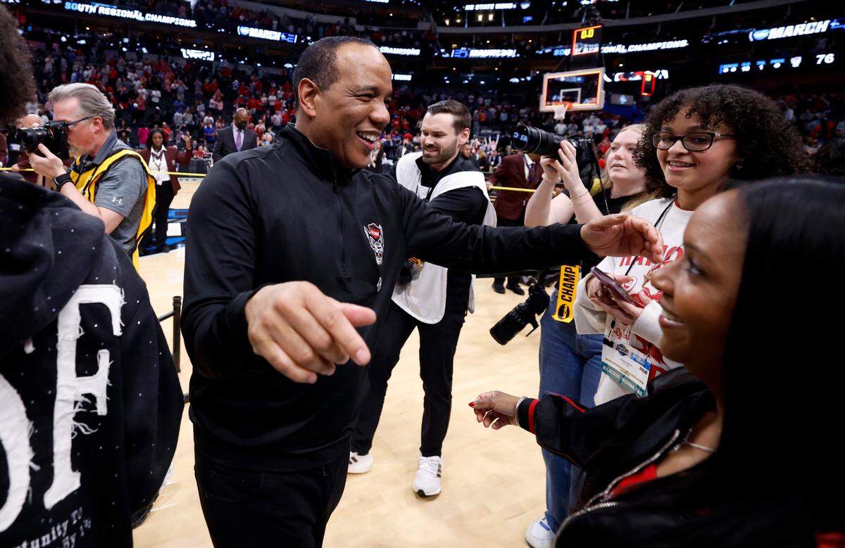 N.C. State head coach Kevin Keatts heads to hug his wife Georgette after the Wolfpack’s 76-64 victory over Duke in NCAA Tournament Elite Eight game at the American Airlines Center in Dallas, Texas, Sunday, March 31, 2024.