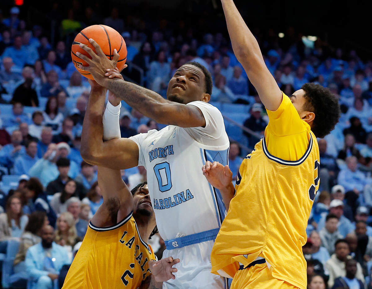 North Carolina’s Ty Claude is fouled as he drives to the basket past La Salle’s Corey McKeithan and Tunde Vahlberg Fasasi during the second half of the Tar Heels’ 93-67 win on Saturday, Dec. 14, 2024, at the Smith Center in Chapel Hill, N.C.