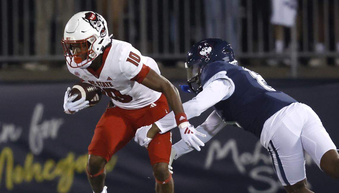 N.C. State’s Kevin Concepcion (10) avoids Connecticut cornerback Mumu Bin-Wahad (6) during the first half of N.C. State’s game against UConn at Rentschler Field in East Hartford, Conn. Thursday, August 31, 2023.