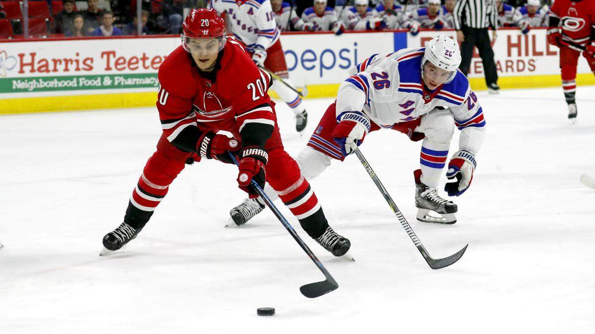 The Canes' Sebastian Aho (20) moves the puck against the Rangers' Jimmy Vesey (26) during the first period.  Aho, a rising star for the Canes, was mic'd up for the TV broadcast during the game.