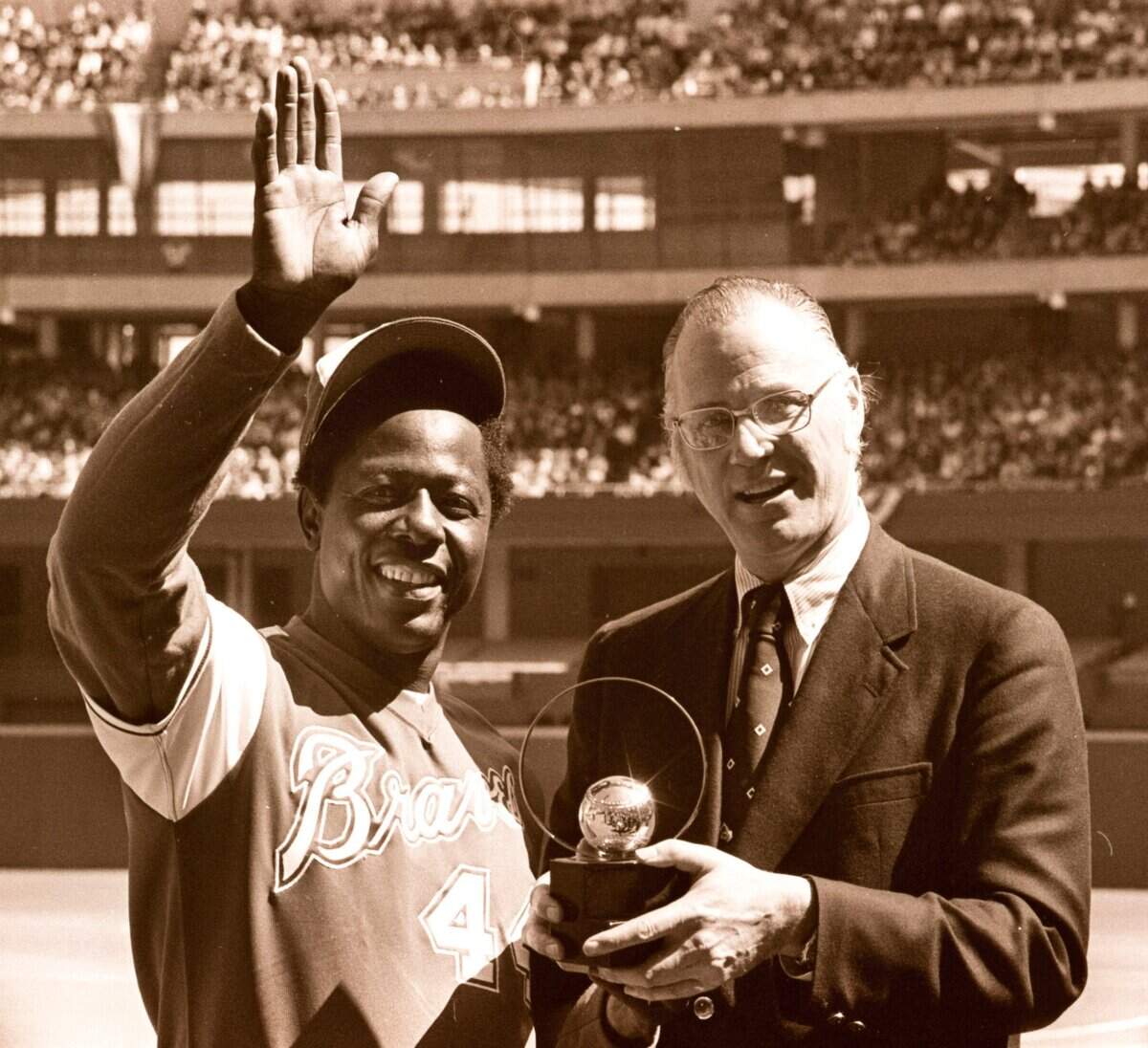 In this April 4, 1974, file photo, baseball commissioner Bowie Kuhn, right, presents Atlanta Braves’ Hank Aaron with a trophy after he tied Babe Ruth’s all-time home run record in Cincinnati.