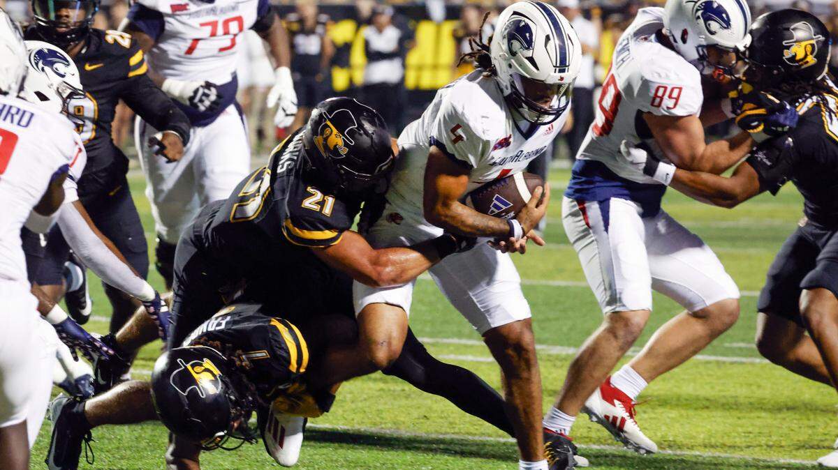 Sep 19, 2024; Boone, North Carolina, USA; Appalachian State Mountaineers safety Jordan Favors (7) and safety DJ Burks (21) tackle South Alabama Jaguars quarterback Gio Lopez (7) during the second half at Kidd Brewer Stadium. Mandatory Credit: Reinhold Matay-Imagn Images