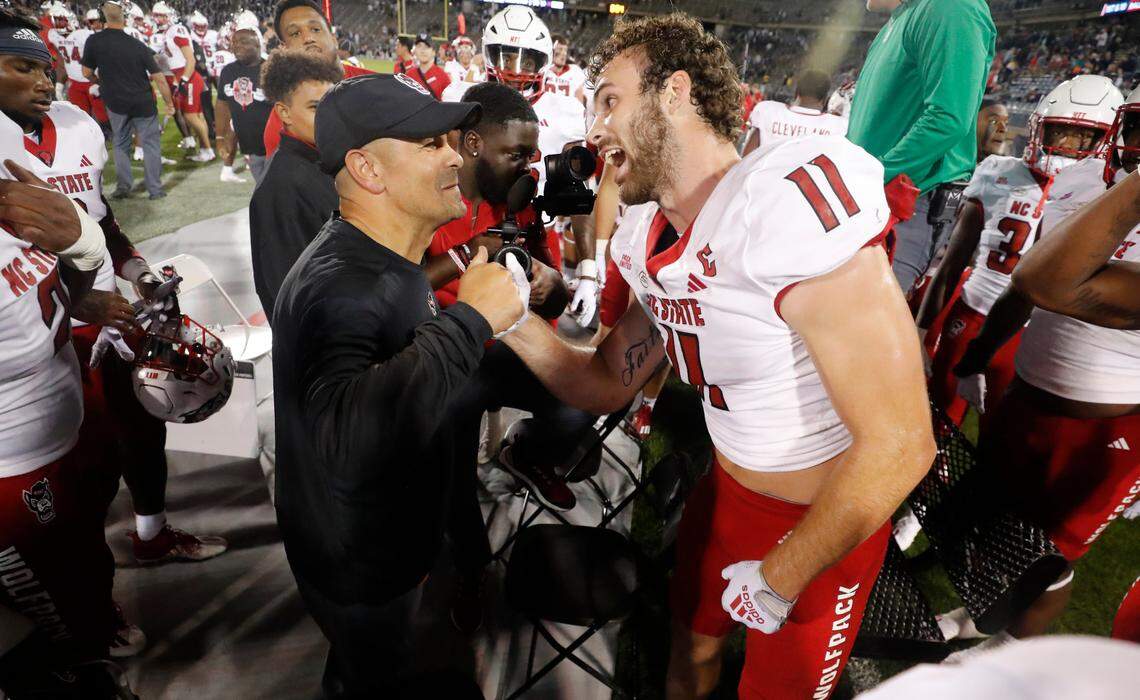 N.C. State defensive coordinator Tony Gibson congratulates Payton Wilson (11) after he intercepted the ball during the second half of N.C. State’s 24-14 victory over UConn at Rentschler Field in East Hartford, Conn. Thursday, August 31, 2023.