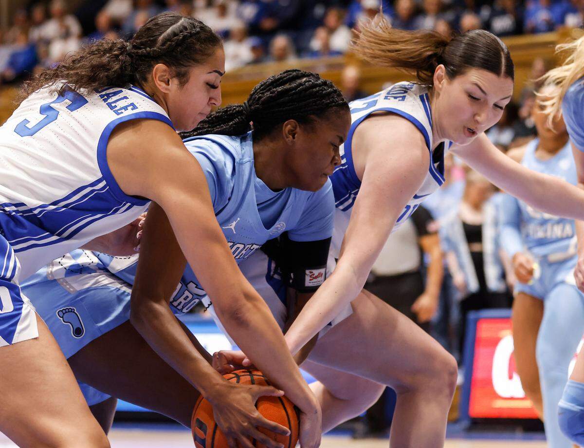 Duke’s Taya Corosdale and Mia Heide fight for a loose ball with North Carolina’s Anya Poole during the first half of the Tar Heels’ 45-41 win over Duke on Sunday, Feb. 26, 2023, at Cameron Indoor Stadium in Durham, N.C.