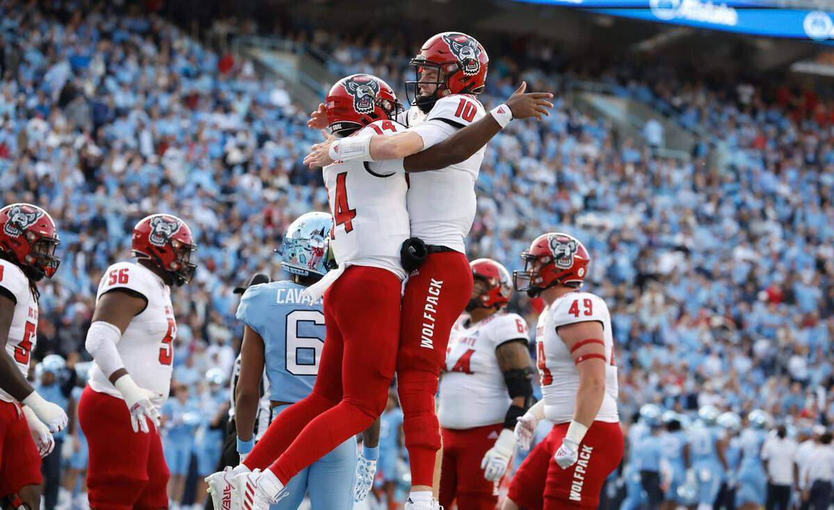 N.C. State quarterback Jack Chambers (14) celebrates with quarterback Ben Finley (10) after Chambers scored on a two-yard touchdown run during the first half of N.C. State’s game against UNC at Kenan Stadium in Chapel Hill, N.C., Friday, Nov. 25, 2022.