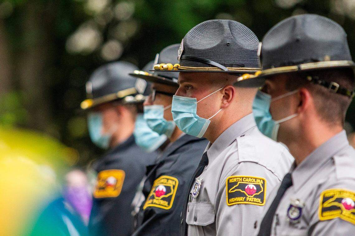 North Carolina State Highway Patrol officers wear masks while guarding the North Carolina Confederate Monument during a protest on Juneteenth, Friday, June 19, 2020 at the State Capitol.