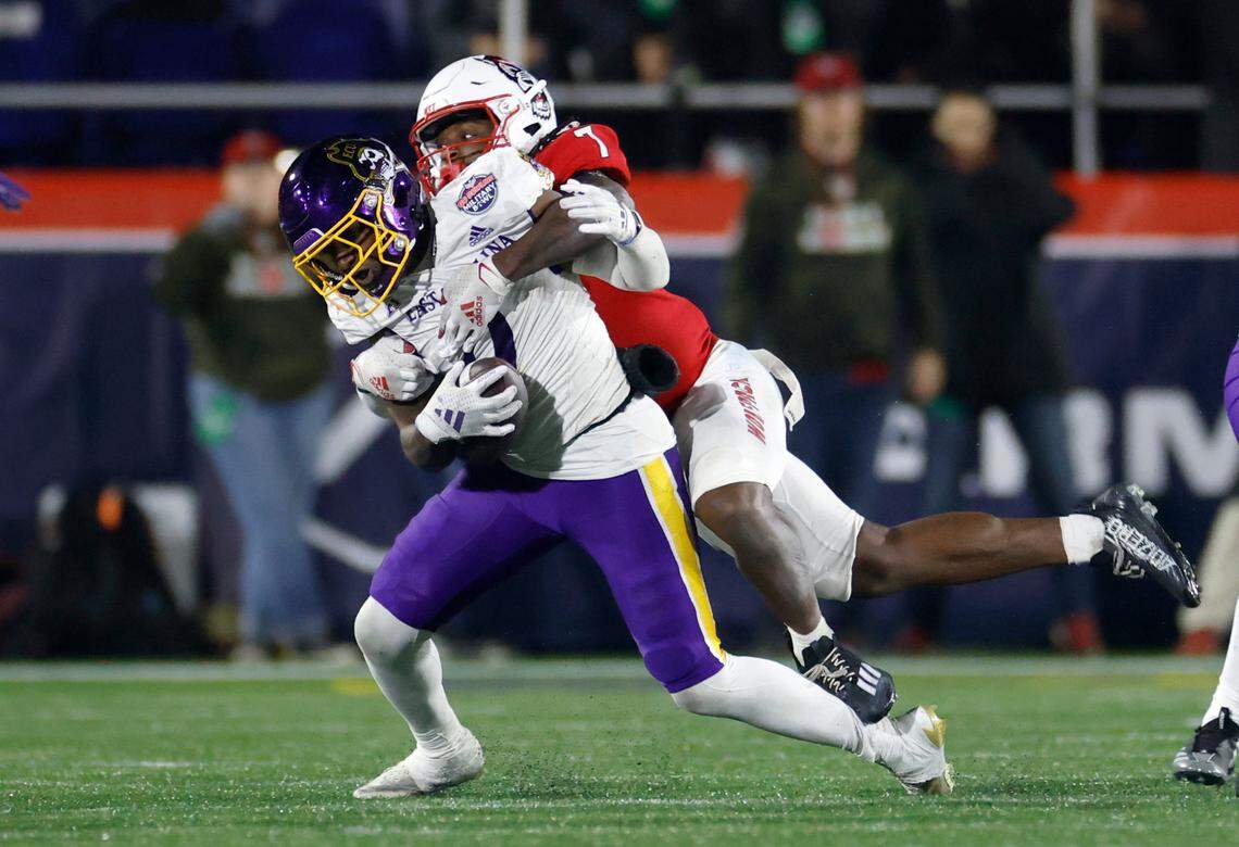 N.C. State safety Bishop Fitzgerald (7) stops East Carolina wide receiver Jhari Patterson (0) during the second half of ECU’s 26-21 victory over N.C. State in the Military Bowl at Navy-Marine Corps Memorial Stadium in Annapolis, Md., Saturday, Dec. 28, 2024.
