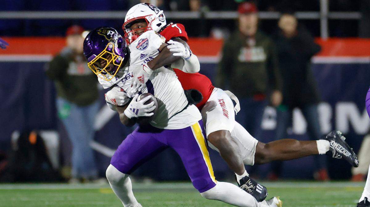 N.C. State safety Bishop Fitzgerald (7) stops East Carolina wide receiver Jhari Patterson (0) during the second half of ECU’s 26-21 victory over N.C. State in the Military Bowl at Navy-Marine Corps Memorial Stadium in Annapolis, Md., Saturday, Dec. 28, 2024.