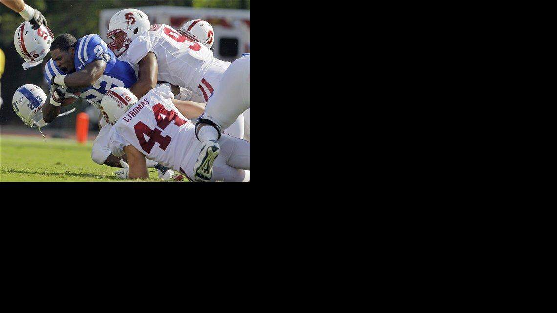Stanford’s Chase Thomas (44) and James Vaughters tackle Duke’s Juwan Thompson (23) during the first half of an NCAA college football game in Durham.