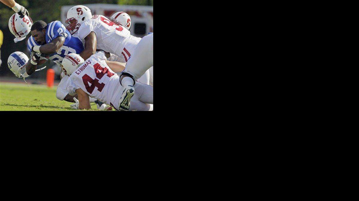 Stanford’s Chase Thomas (44) and James Vaughters tackle Duke’s Juwan Thompson (23) during the first half of an NCAA college football game in Durham.