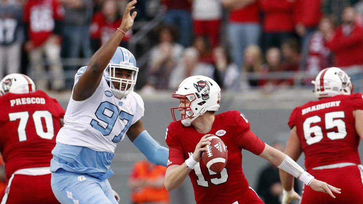 UNC’s Jalen Dalton (97) pressures NC State QB Ryan Finley (15) during the first quarter of an ACC college football game between the N.C. State Wolfpack and the UNC Tar Heels played at Carter-Finley Stadium in Raleigh, NC, on Nov. 25, 2017.  N.C. State beat UNC 33-21.