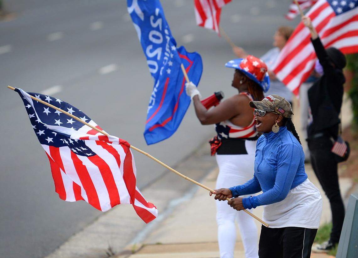 Participants in a ReOpen NC/Memorial Day rally chant slogans as traffic passes along Fairview Road in Charlotte, NC on Monday, May 25, 2020. 