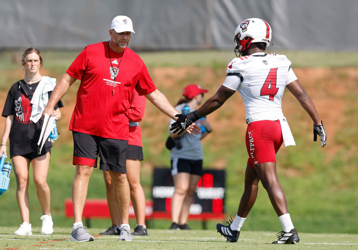 N.C. State head coach Dave Doeren congratulates wide receiver Porter Rooks (4) during the Wolfpack’s first practice of fall camp in Raleigh, N.C., Wednesday, August 3, 2022.