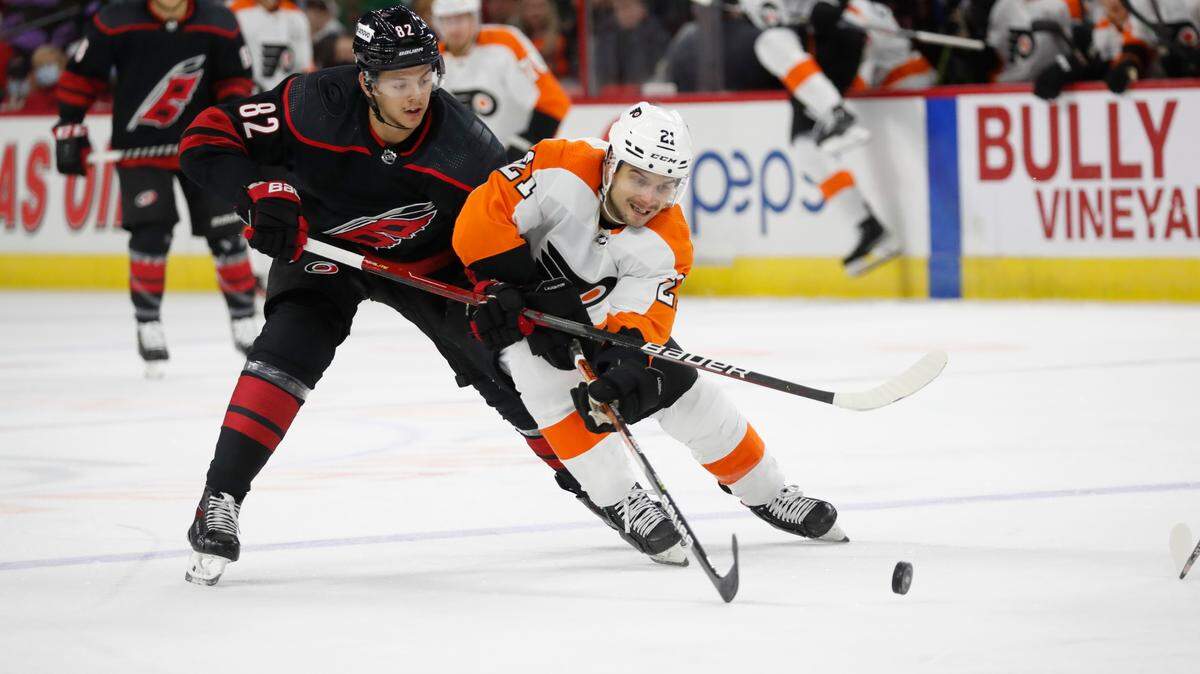 Carolina Hurricanes’ Jesperi Kotkaniemi (82) tangles with Philadelphia Flyers’ Scott Laughton (21) during the first period of an NHL hockey game in Raleigh, N.C., Friday, Nov. 12, 2021. (AP Photo/Karl B DeBlaker)