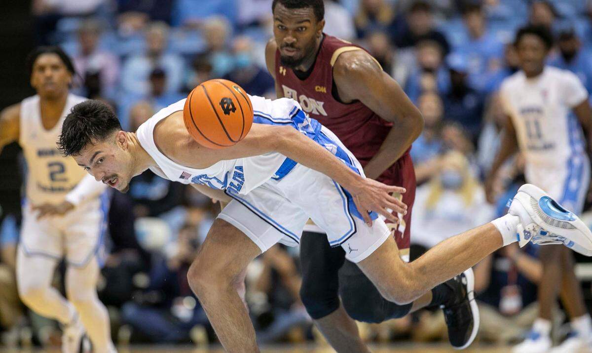 North Carolina’s Dawson Garcia (13) makes a steal from Elon’s Chuck Hannah (1) during the second half on Saturday, December 11, 2021 at the Smith Center in Chapel Hill, N.C.