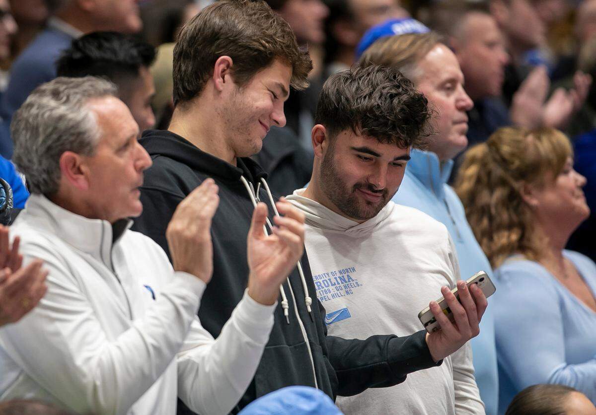 North Carolina quarterback Drake Maye and former quarterback Sam Howell sit behind the North Carolina bench during the Tar Heels’ game against Duke on Saturday, February 4, 2023 at Cameron Indoor Stadium in Durham, N.C.