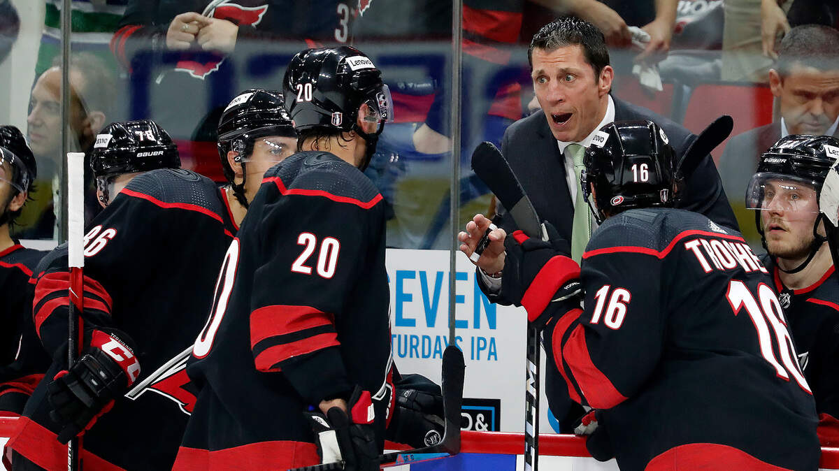 Carolina Hurricanes head coach Rod Brind’Amour talks with Carolina Hurricanes’ Sebastian Aho (20), Teuvo Teravainen (86) and Vincent Trocheck (16) during a timeout in the second period of Game 2 of an NHL hockey Stanley Cup second-round playoff series against the New York Rangers in Raleigh, N.C., Friday, May 20, 2022. (AP Photo/Karl B DeBlaker)