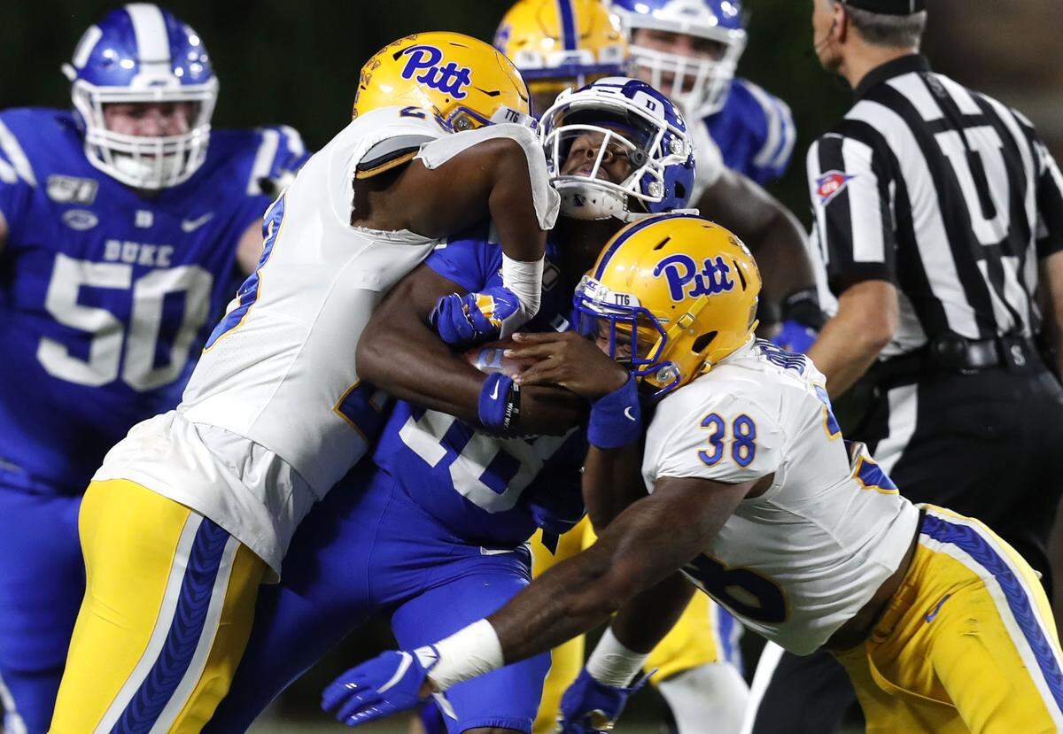 Duke quarterback Quentin Harris (18) is hit by Pittsburgh’s Kylan Johnson (28) and Cam Bright (38) while scrambling for yards during the first half of Duke’s game against Pittsburgh at Wallace Wade Stadium in Durham, N.C., Saturday, Oct. 5, 2019. Harris fumbled the ball on the play and Pittsburgh recovered.