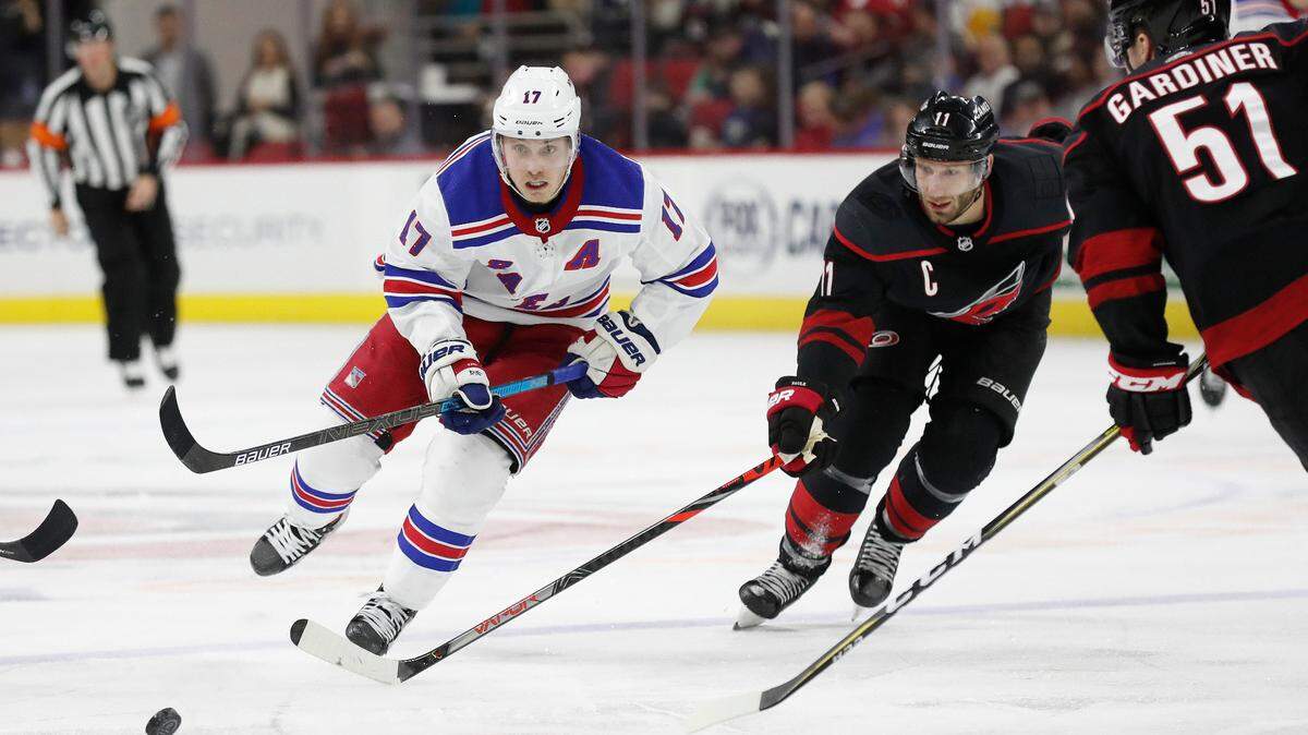 New York Rangers right wing Jesper Fast (17) and Carolina Hurricanes center Jordan Staal (11) skate for the puck during the third period of an NHL hockey game in Raleigh, N.C., Friday, Feb. 21, 2020. (AP Photo/Gerry Broome)
