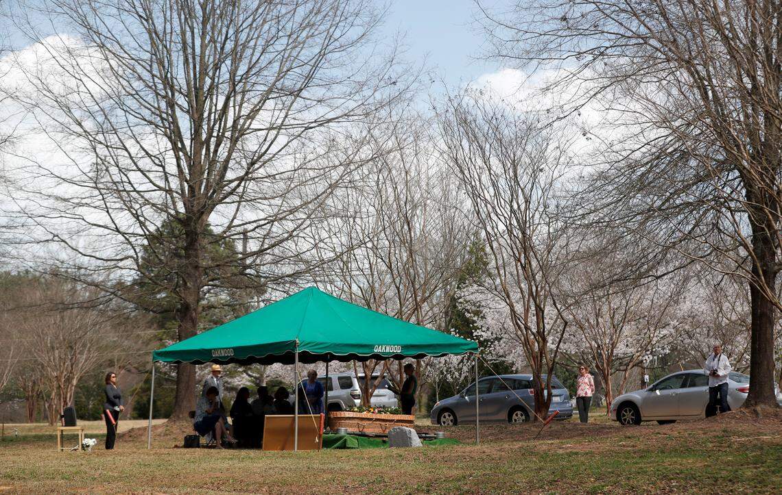 Andy Medlin and close family members attend a graveside service for his mother, Doris Medlin, at the Historic Oakwood Cemetery in Raleigh, N.C., Friday, March 20, 2020.