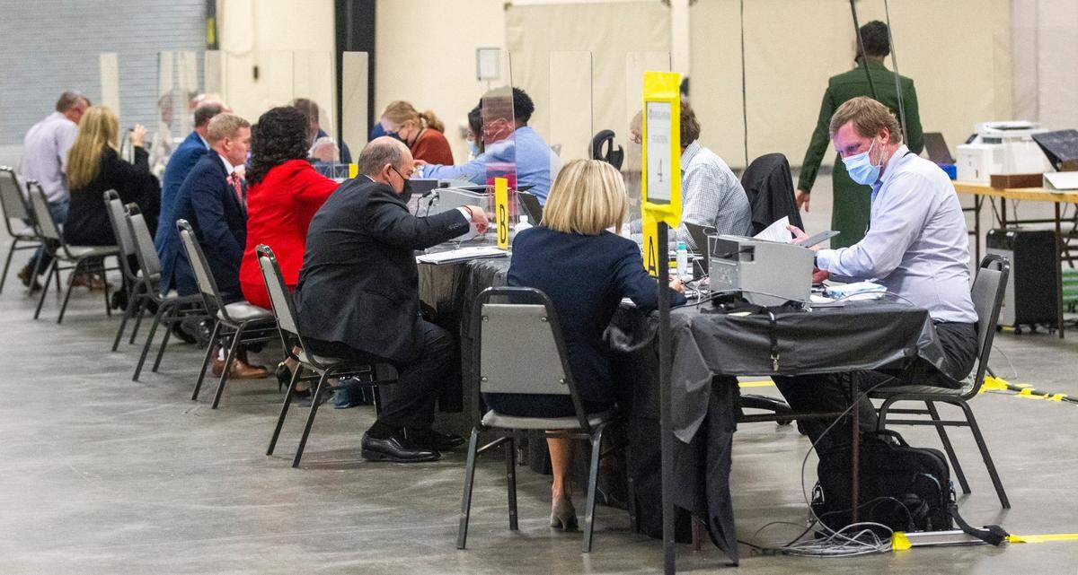 State Board of Elections workers help candidates file for federal, state and local races at the NC State Fairgrounds Monday, Dec. 6, 2021. A court order Monday temporarily blocked U.S. House, state Senate and state House seat candidates from filing to run in the 2022 elections under the districts drawn by Republican state lawmakers.
