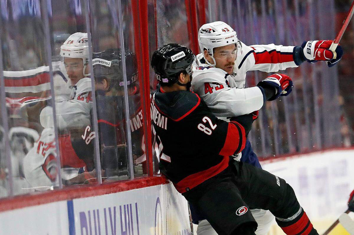 Washington Capitals’ Tom Wilson (43) checks Carolina Hurricanes’ Jesperi Kotkaniemi (82) into the boards during the first period of an NHL hockey game in Raleigh, N.C., Sunday, Nov. 28, 2021. (AP Photo/Karl B DeBlaker)