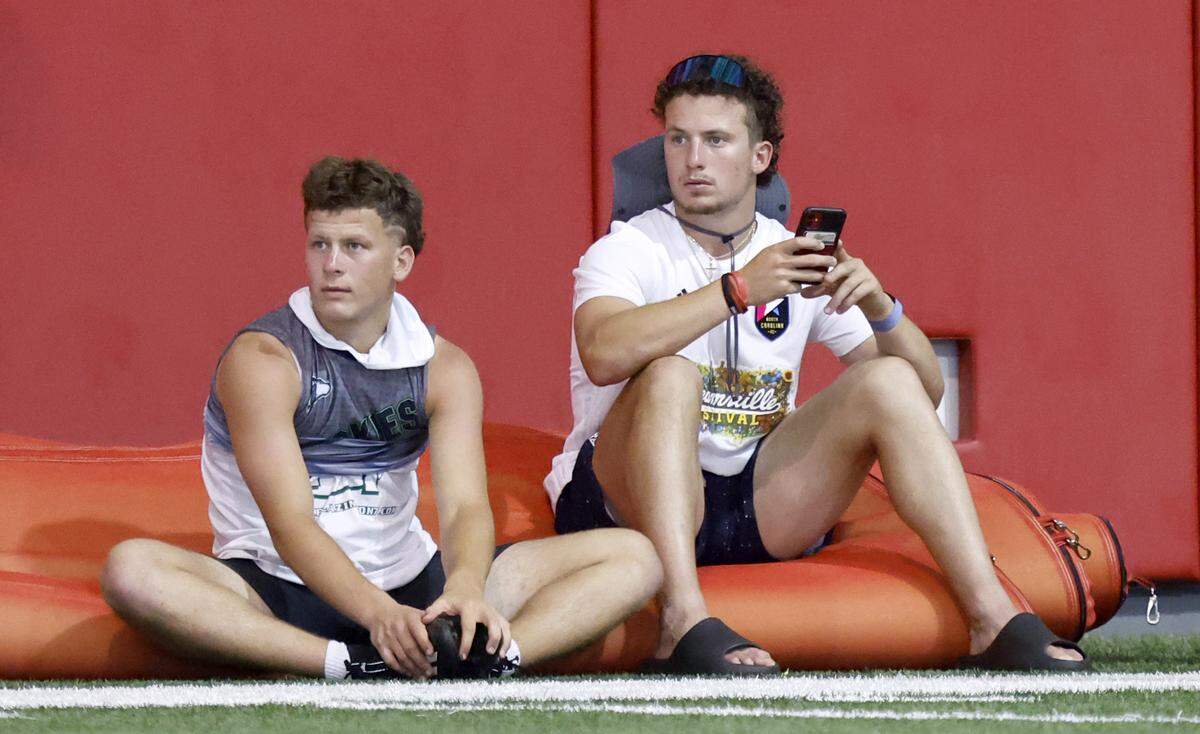Heritage High School’s Lex Thomas, left, and his brother, N.C. State receiver Thayer Thomas, watch drills at the Close-King Indoor Practice Facility in Raleigh, N.C., on Thursday, June 16, 2022.