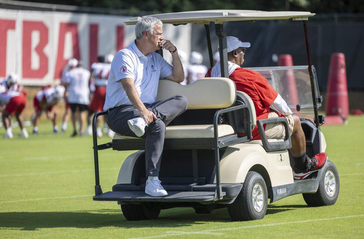 N.C. State Athletic Director Boo Corrigan watches the Wolfpack football practice from the back of a golf cart piloted by special assistant to the head coach, Ruffin McNeill on Tuesday, July 30, 2025 in Raleigh, N.C.