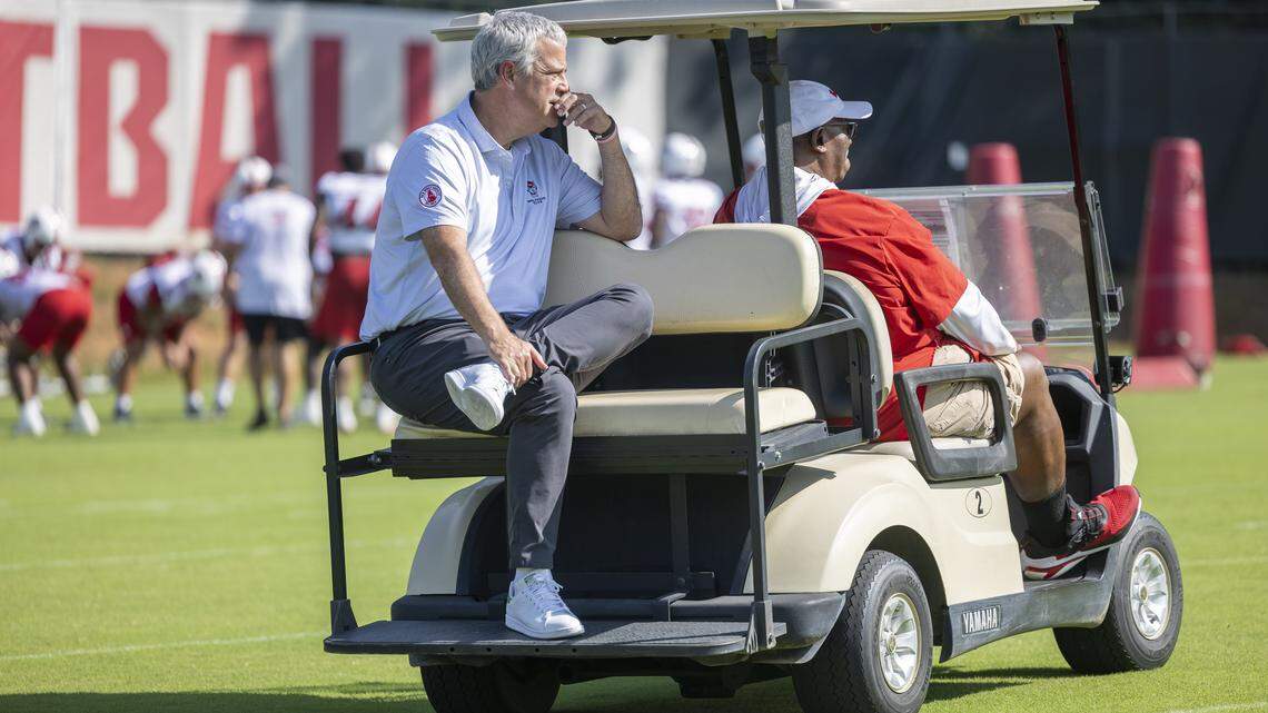 N.C. State Athletic Director Boo Corrigan watches the Wolfpack football practice from the back of a golf cart piloted by special assistant to the head coach, Ruffin McNeill on Tuesday, July 30, 2025 in Raleigh, N.C.