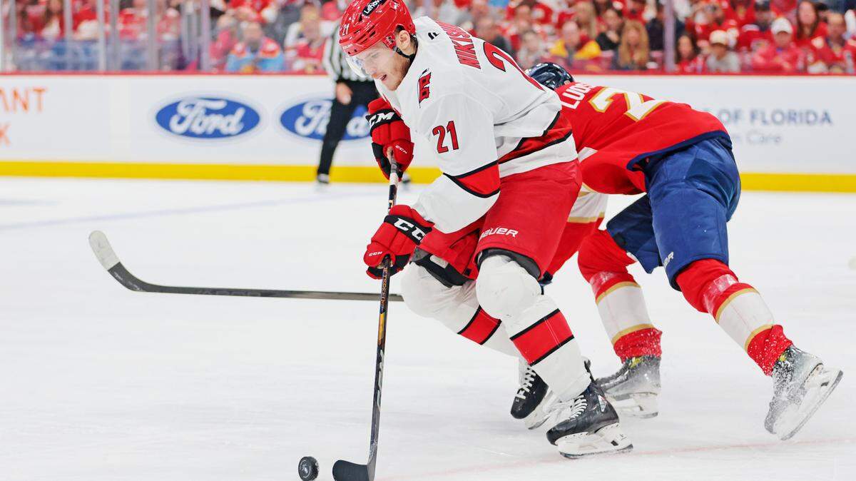 May 26, 2025; Sunrise, Florida, USA; Carolina Hurricanes defenseman Alexander Nikishin (21) moves the puck during the third period against the Florida Panthers in game four of the Eastern Conference Final of the 2025 Stanley Cup Playoffs at Amerant Bank Arena. 
