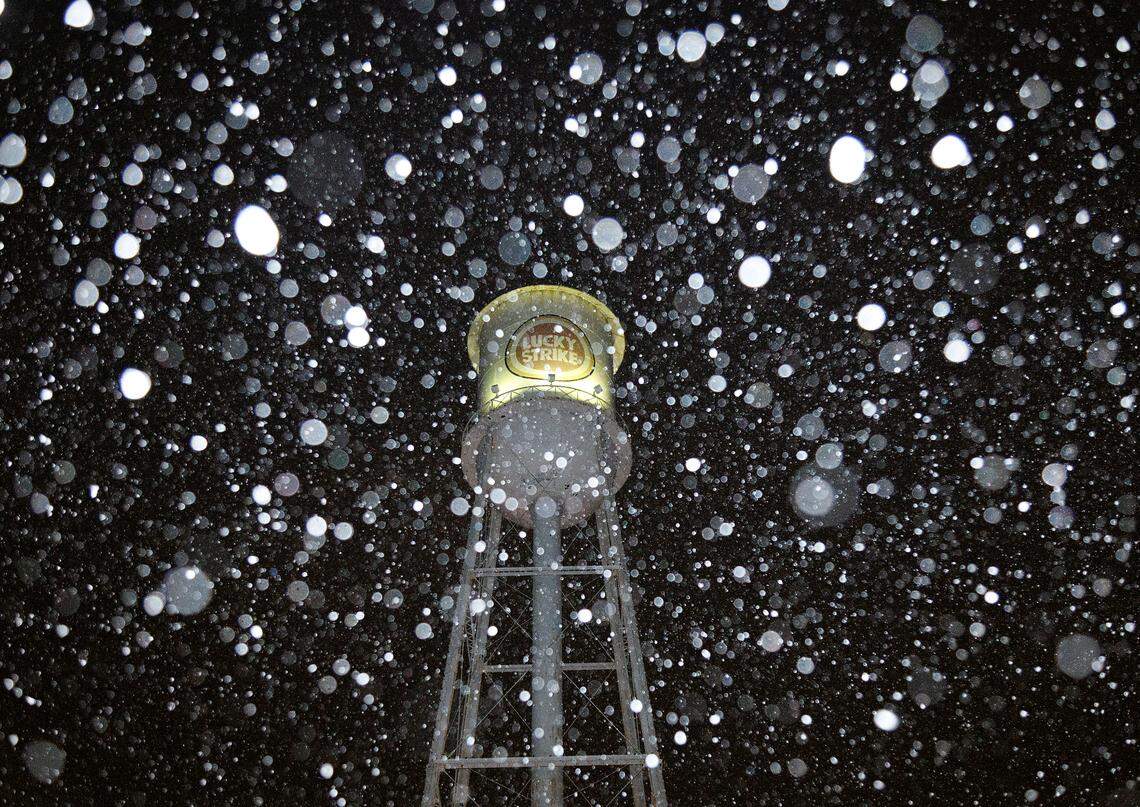 Snow falls near the Lucky Strike tower in the American Tobacco Campus on Tuesday, Jan. 21, 2025, in Durham, N.C.