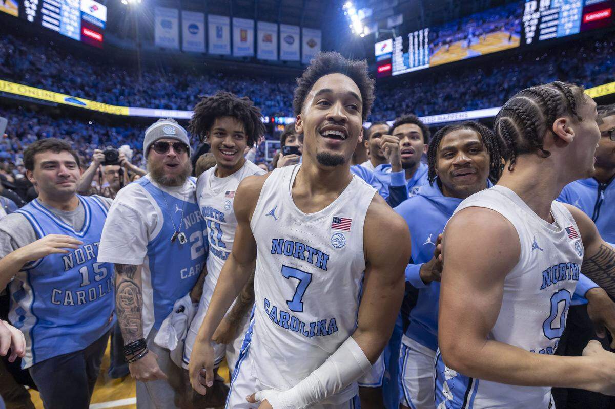 North Carolina guard Seth Trimble (7) reacts as fans storm the court, after sinking a three-point shot with .4 seconds to play, to give the Tar Heels a 71-68 victory over Duke on Saturday, February 7, 2026 at the Smith Center in Chapel Hill, N.C.