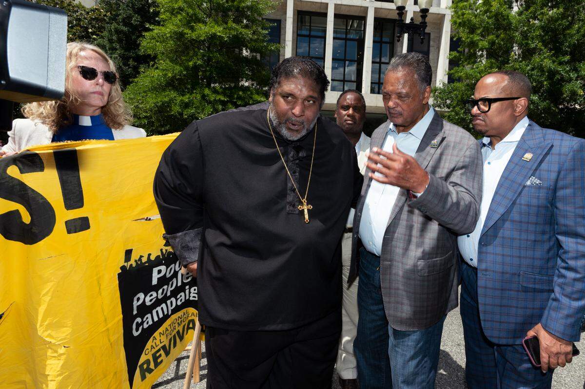 Rev. Jesse Jackson, second from right, and Rev. William Barber II, second from left, stand in front of Hart Senate Office building in in Washington, blocking the street, Wednesday, June 23, 2021.
