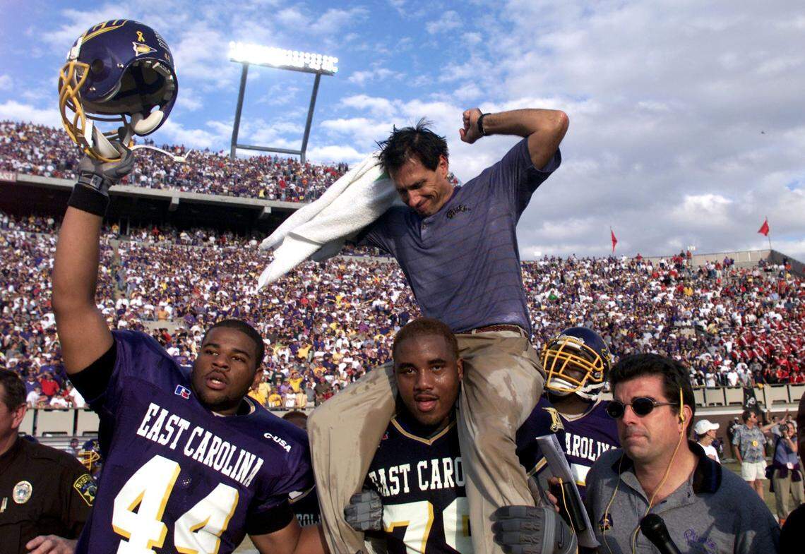 -ECU coach Steve Logan celebrates as he is carried off the field by his players after they defeated N.C. State 23-6 in Greenville in 1999.
