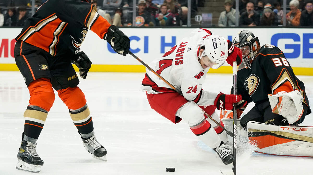 Anaheim Ducks defenseman Cam Fowler, left, and goaltender John Gibson (36) defend against Carolina Hurricanes center Seth Jarvis (24) during the third period of an NHL hockey game in Anaheim, Calif., Thursday, Nov. 18, 2021. (AP Photo/Ashley Landis)
