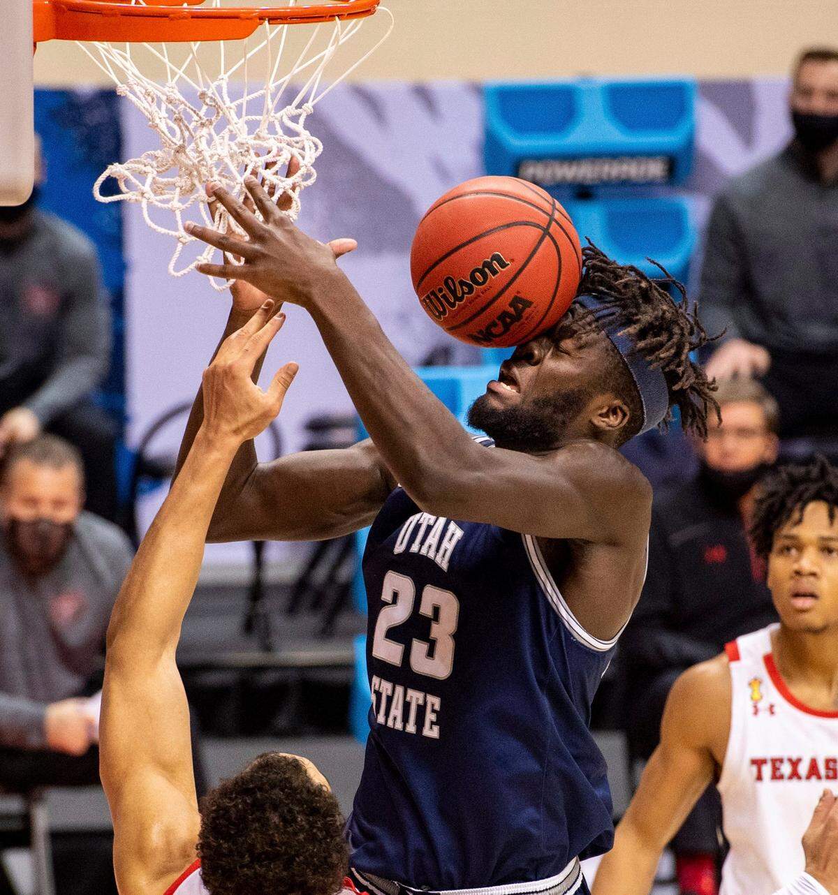 The basketball hits the face of Utah State center Neemias Queta (23) after his layup attempt ricocheted off the rim during the first half of a first round game against Texas Tech in the NCAA men’s college basketball tournament, Friday, March 19, 2021, in Bloomington, Ind. (AP Photo/Doug McSchooler)