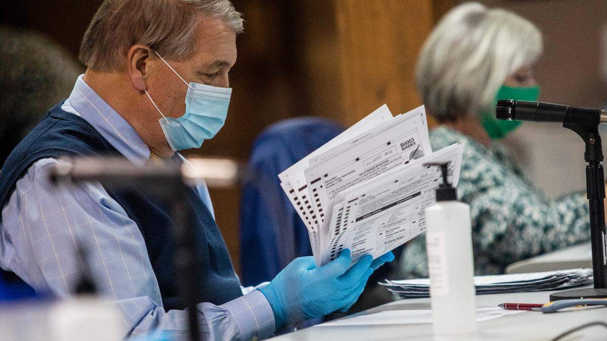 Johnston County Board of Elections members process absentee ballots in November 2020. The state has released a schedule for mailing out absentee ballots without Robert F. Kennedy Jr. listed as a candidate.