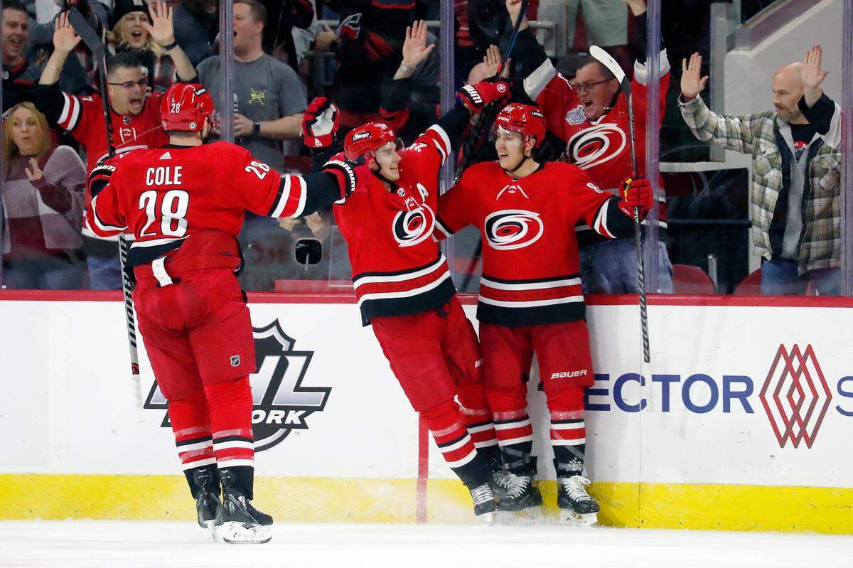 Carolina Hurricanes’ Teuvo Teravainen (86) right, celebrates his goal with teammates Sebastian Aho (20) center, and Ian Cole (28) during the first period of an NHL hockey game against the Montreal Canadiens in Raleigh, N.C., Thursday, Dec. 30, 2021. (AP Photo/Karl B DeBlaker)