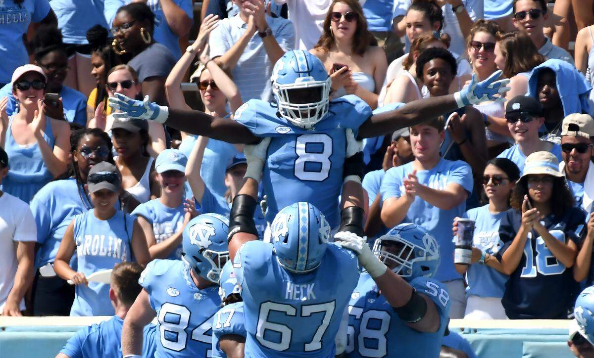 UNC running back Michael Carter (8) is held aloft by teammate offensive tackle Charlie Heck (67) after scoring a touchdown in the second quarter. UNC played Pittsburgh in Chapel Hill, N.C. Saturday, Sept.22, 2018.