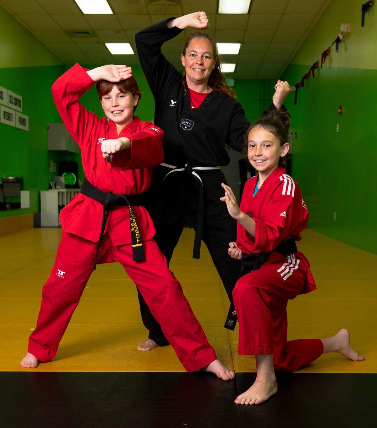 Laura Campbell and her two sons, Jacob and Isaac, pose for a portrait at Master Chang’s Martial Art Studio in Durham, N.C. on June 4, 2024. Isaac describes taekwondo as his family’s happy place.