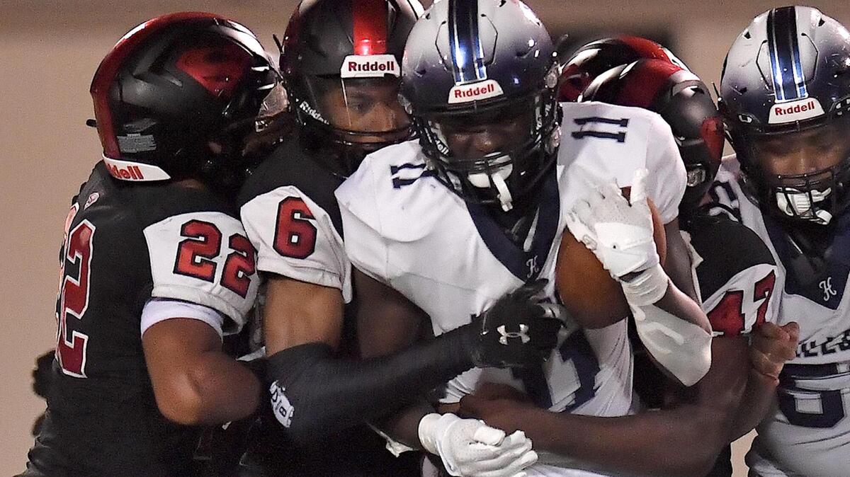 Hillside’s Ameil Braswell (11) is grappled by the Southern Durham defense during the first half. The Southern Durham Spartans and the Hillside Hornets met in a non-conference football game at Durham County Stadium on August 25, 2023.