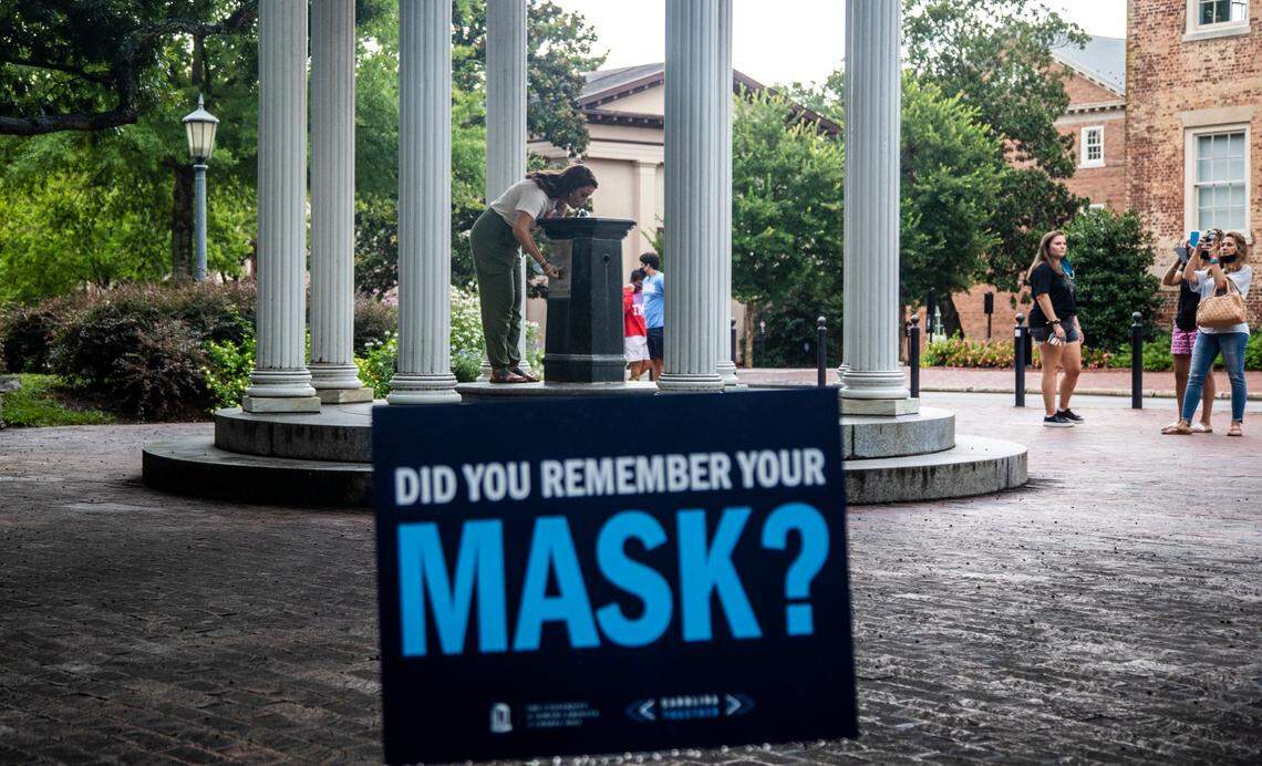 A sign at the Old Well at UNC-Chapel Hill encourages wearing a mask amid the coronavirus pandemic Thursday, August 7, 2020.